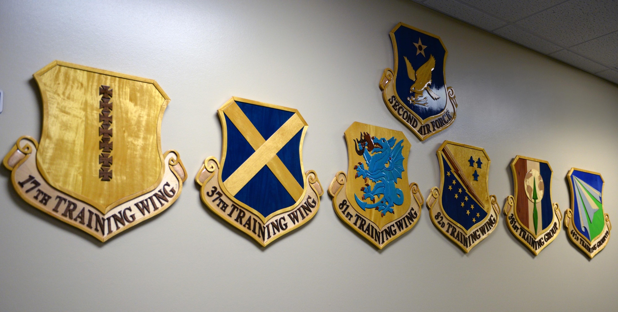 Wing shields hang on the wall at the 81st Training Support Squadron Military Training Leader School’s new location in Lott Hall, July 17, 2017, on Keesler Air Force Base, Miss. The course recently moved locations from Allee Hall to Lott Hall, and now features its own dedicated classroom, CPR training room, conference room and instructor offices, as well as additional resources and career field heritage pieces. (U.S. Air Force photo by 2nd Lt. Toney Doan)