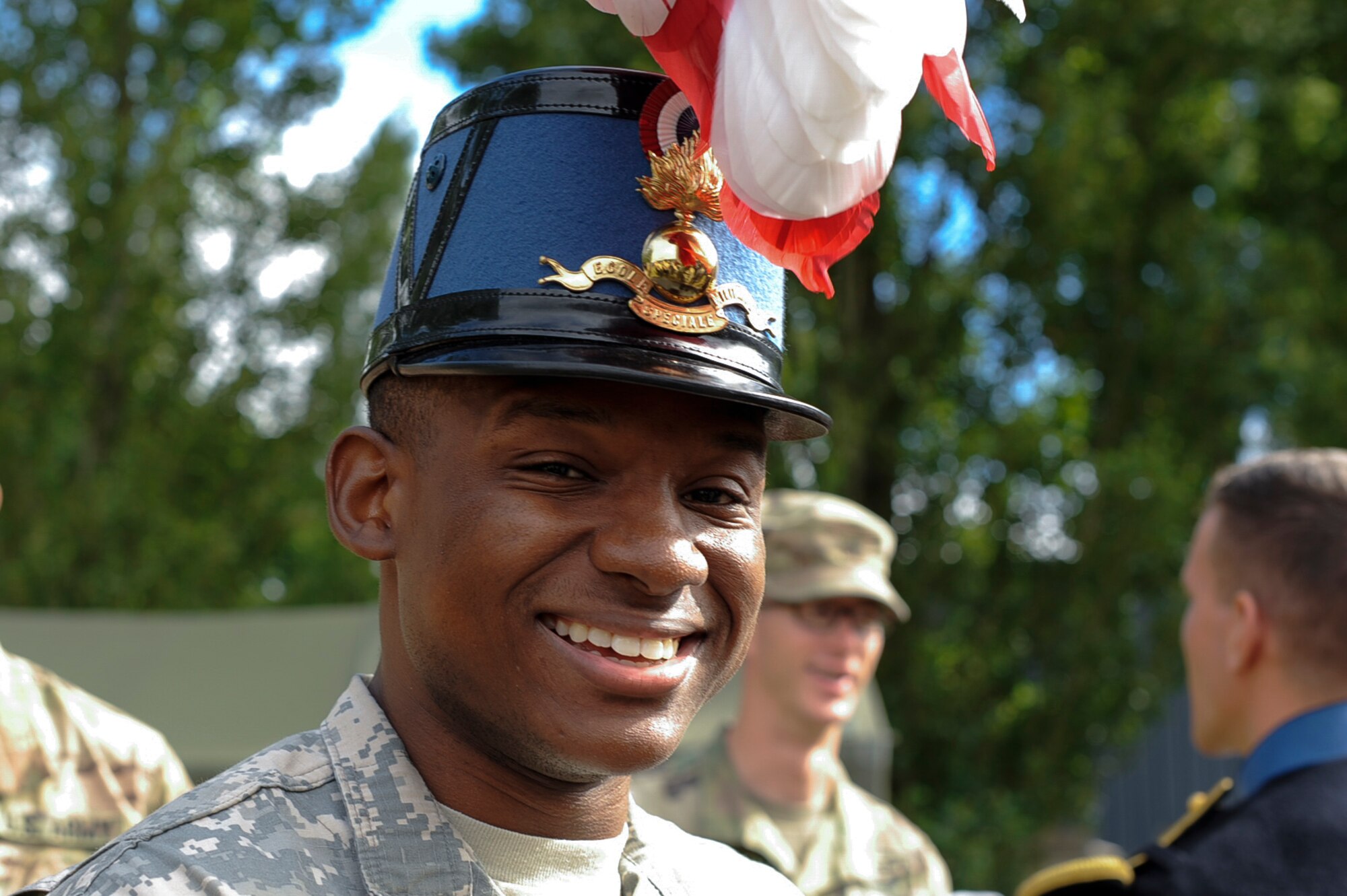 A U.S. Army soldier tries on an Armée de Terre member’s headgear at Camp de Satory, France, July 12, 2017. U.S. military members arrived at Lycee Militaire de Saint-Cyr and stayed for over a week to participate in and prepare for France’s Bastille Day military parade on July 14, 2017. (U.S. Air Force photo by Airman 1st Class Savannah L. Waters)