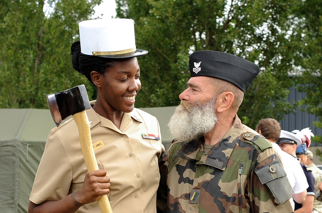A U.S. Navy Seaman and a member of the Armée de Terre switch hats for a photo at Camp de Satory, France, July 12, 2017. During rehearsals, military members from countries had the opportunity to interact and learn from the other’s military traditions and culture, further strengthening the bond between old allies. (U.S. Air Force photo by Airman 1st Class Savannah L. Waters)