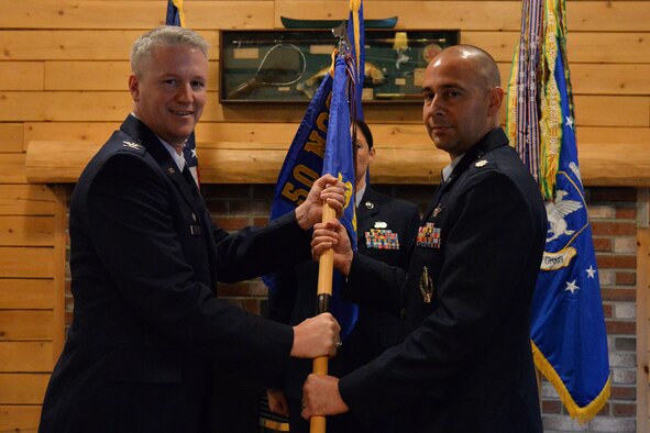 Col. William Angerman, 50th Network Operations Group commander, hands the 23rd Space Operations Squadron guidon to the squadron’s new commander, Lt. Col. Kenneth Holmes, during the unit’s change of command ceremony at New Boston Air Force Station, New Hampshire, July 11, 2017. Holmes was preceded by Lt. Col. Marty Easter. (Courtesy photo) 