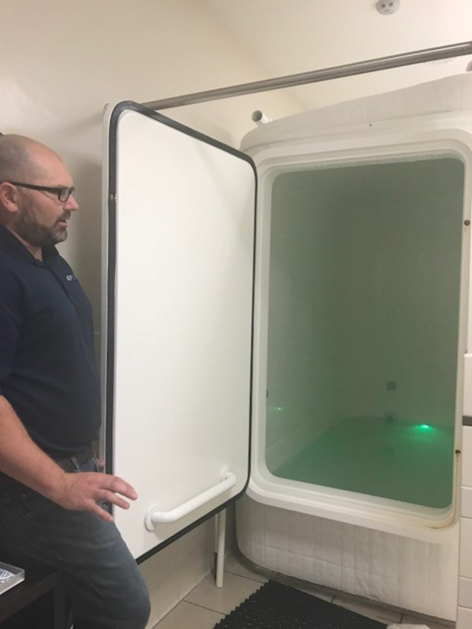 Dr. Josh Hagen, 711th Human Performance Wing Airman Systems Signature Tracking for Optimized Nutrition and Training (STRONG) team lead, explains how Flotation Restricted Environmental Stimulating Therapy (REST) is administered. Flotation-REST a sensory deprivation tank containing 900 pounds of epsom salt in body temperature water, which gives the feeling of weightlessness. The flotation therapy users float 45 to 60 minutes once a week putting them directly back in sympathetic/parasympathetic balance. (U.S. Air Force photo/Stacey Geiger)  