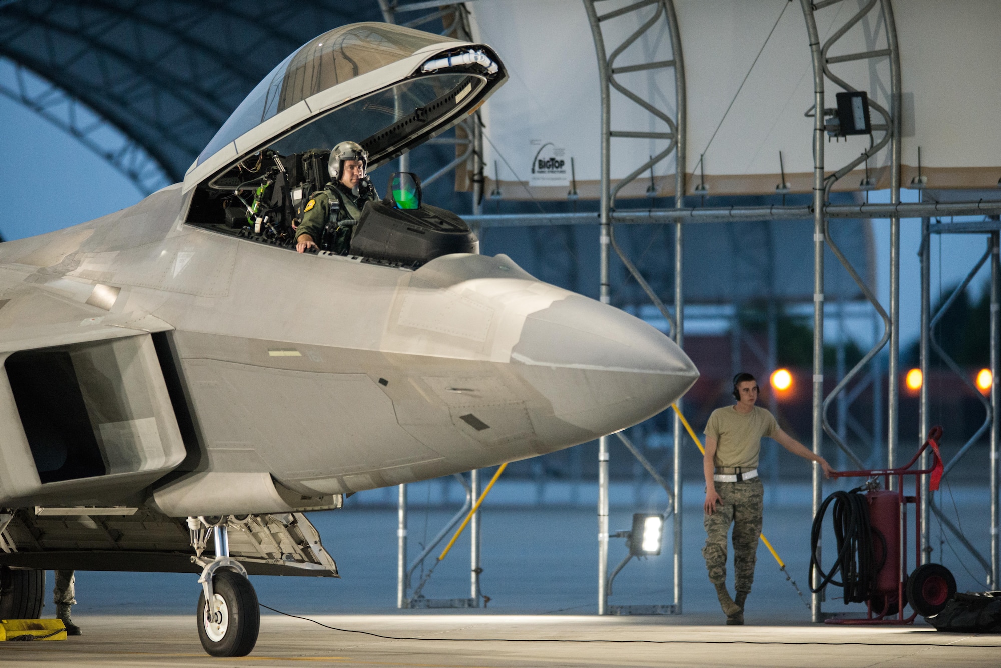 A 1st Fighter Wing F-22 pilot and maintenance Airman prepare to launch a jet for take off at Joint Base Langley-Eustis, Va., July 11, 2017. The wing conducted night flying training missions to keep pilots current on skills needed to operate in the dark. (U.S. Air Force Photo/Master Sgt. Benjamin Wilson)