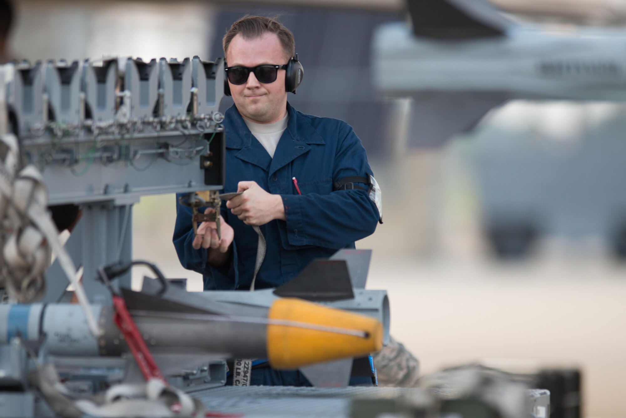 U.S. Air Force Staff Sgt. Jonathan Deacon, 1st Aircraft Maintenance Squadron weapons team chief, secures a weapons load trailer while loading training munitions on to an F-22 Raptor at Joint-Base Langley-Eustis, Va., July 11, 2017. The 1st Fighter Wing conducted night flying operations to give pilots an opportunity to maintain currencies on skills required to fly in the dark.  (U.S. Air Force Photo/Master Sgt. Benjamin Wilson)