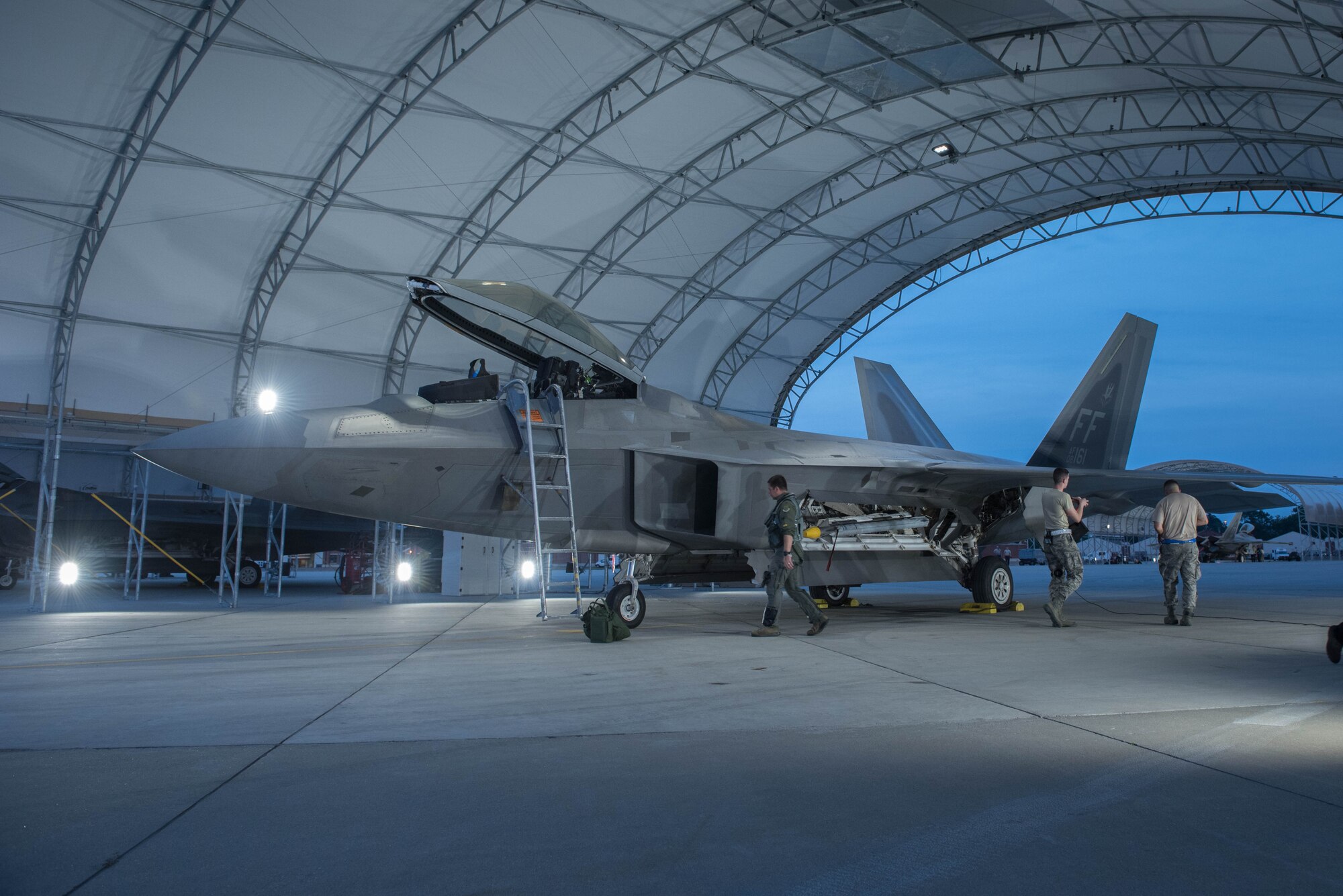 A U.S. Air Force F-22 Raptor pilot assigned to the 1st Fighter Wing, completes pre-flight inspections, during night operations at Joint Base Langley-Eustis, Va., July 11, 2017. Night operations allow pilots to maximize combat readiness in the 1st FW's lines of effort and maintain night navigation proficiency. (U.S. Air Force photo/Staff Sgt. Carlin Leslie)