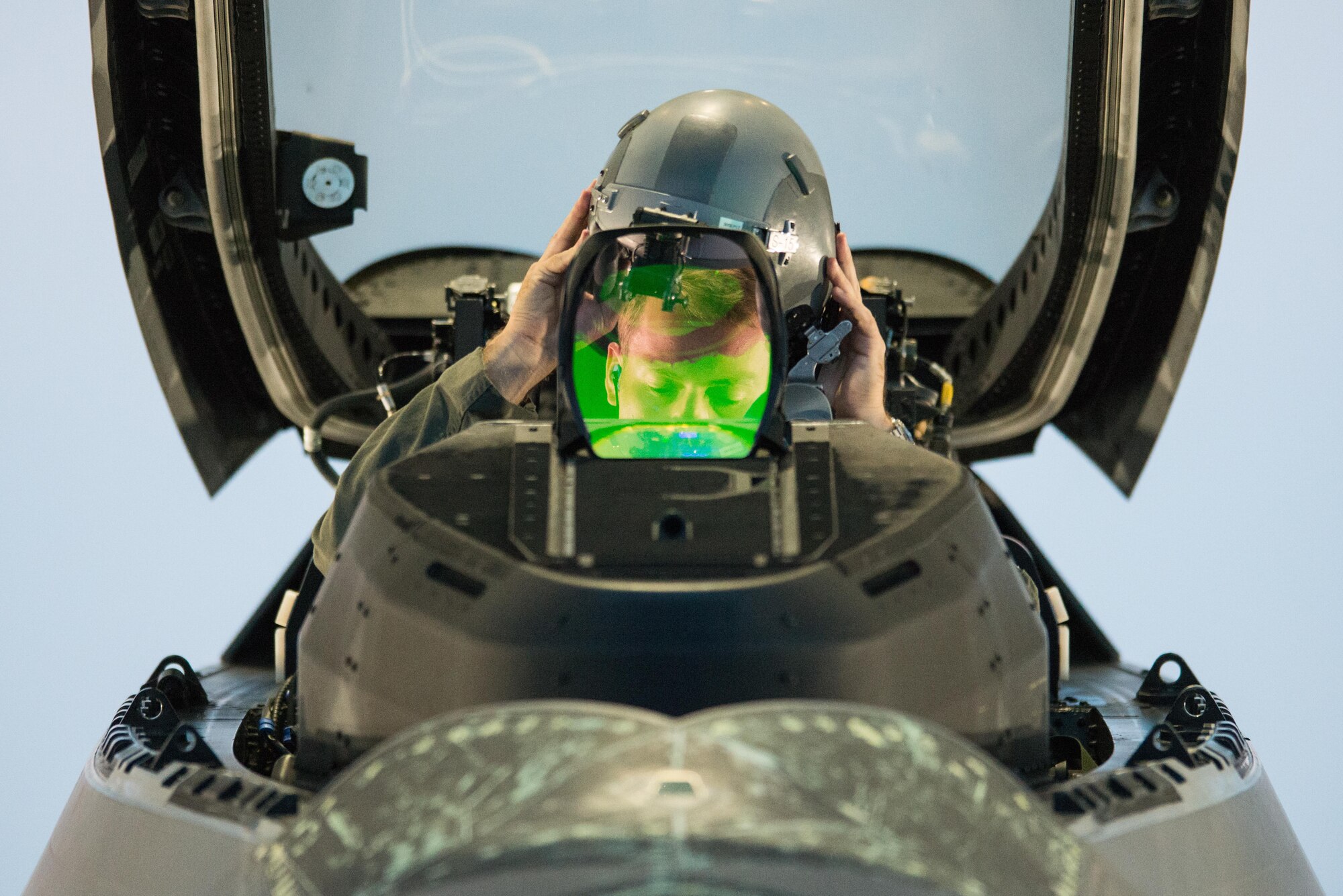 A 94th Fighter Squadron pilot dons his helmet before departing Joint Base Langley-Eustis, Va., July 11, 2017. During the mission, the pilots were practiced defensive and offensive counter air operations. (U.S. Air Force Photo/Master Sgt. Benjamin Wilson)