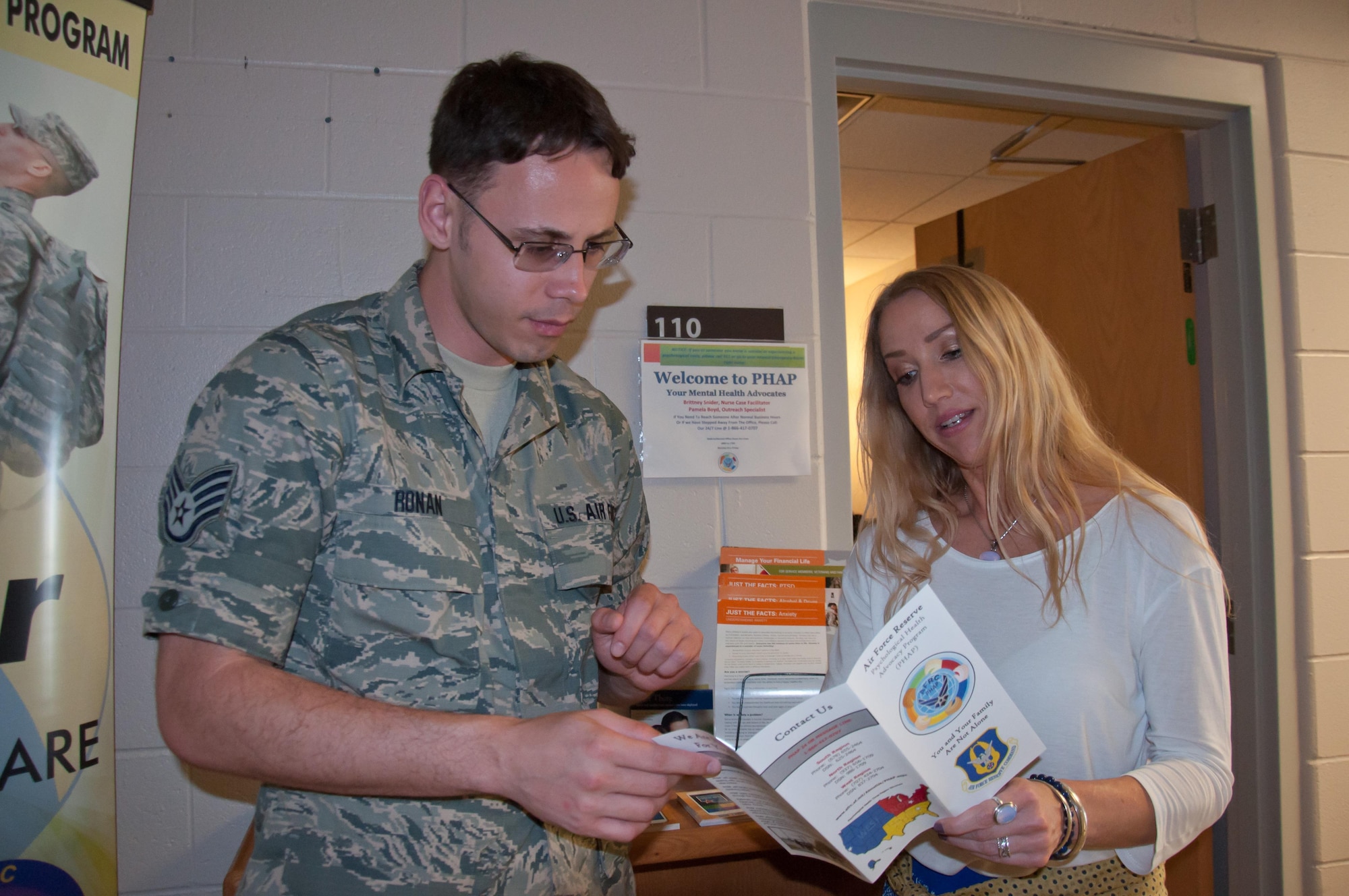 Pamela Boyd, Psychological Health Advocacy Program Outreach Specialist, provides program literature to Staff Sgt. Samuel Ronan, 445th Customer Support NCOIC, to support the 3,000 members of the reserve squadron June 15, 2017. PHAP assists members and families as they deal with life’s stressors. (U.S. Air Force photo/John Harrington)