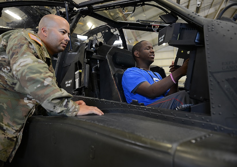U.S. Army Staff Sgt. Edmar DeJesus, 1st Battalion, 210th Aviation Regiment, 128th Aviation Brigade AH-64D Apache helicopter instructor, helps Barry Brown, Ready 2 Work program participant, operate a camera in an AH-64D Apache helicopter at Joint Base Langley-Eustis, Va., July 14, 2017. Ready 2 Work is a six-week work program, which teaches students how to write resumes, conduct job interviews and learn about career opportunities available to them. (U.S. Air Force photo/Staff Sgt. Teresa J. Cleveland)