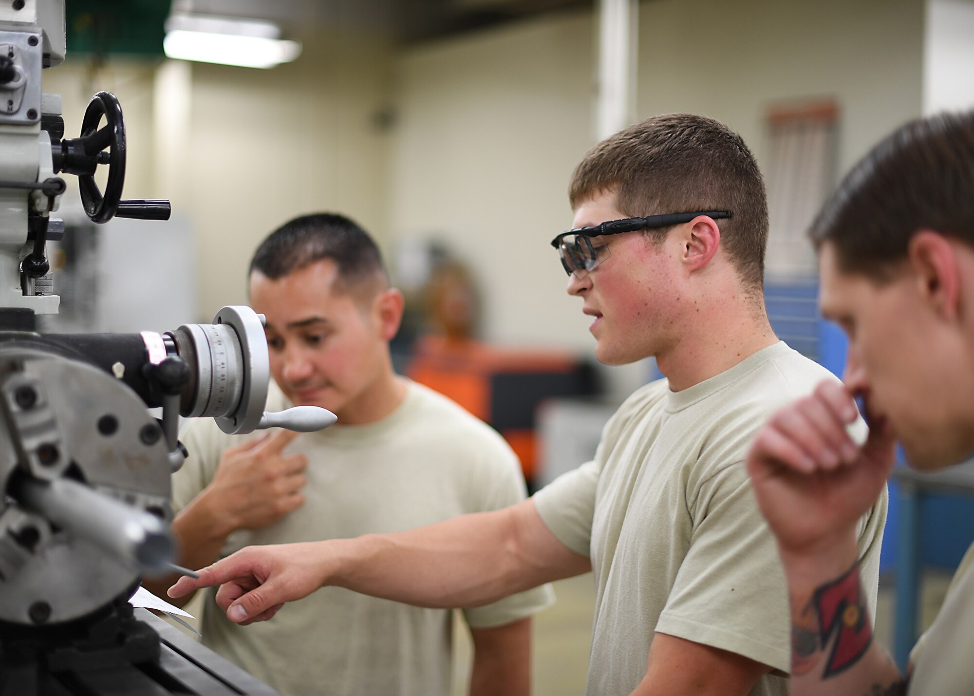 Airmen with the 69th Maintenance Squadron discuss the plans for a part before making the first cut July 13, 2017, on Grand Forks Air Force Base, N.D. These Airmen saved the Air Force money, manpower and mission capabilities by fabricating a part which was unavailable worldwide. (U.S. Air Force photo by Senior Airman Ryan Sparks)