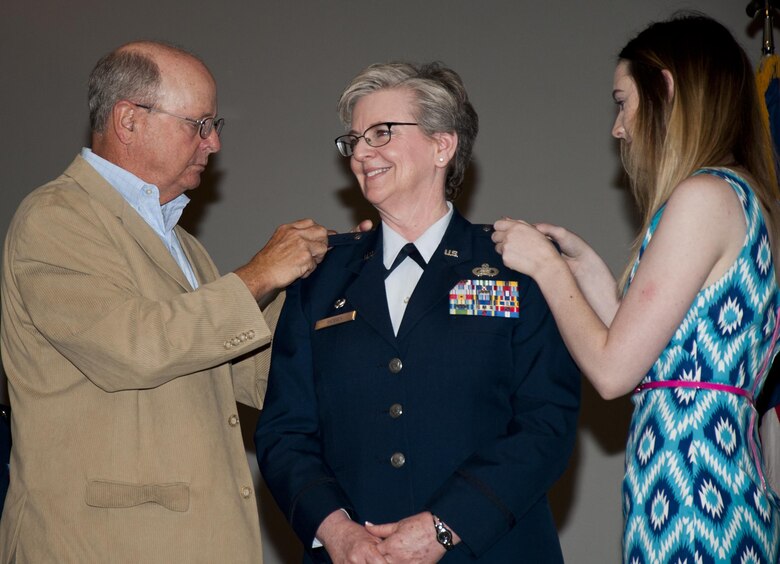 U.S. Air Force Col. Kelly E. Hosey, Commander of the 916th Mission Support Group, has her colonel epaulets put on her uniform by her husband and daughter at Seymour Johnson Air Force Base, N.C., July 16, 2017. Hosey began her career as an enlisted Airman, where she achieved the rank of Chief Master Sergeant prior to earning her commission and becoming a colonel. (U.S. Air Force photo by Senior Airman Kayla Newman)