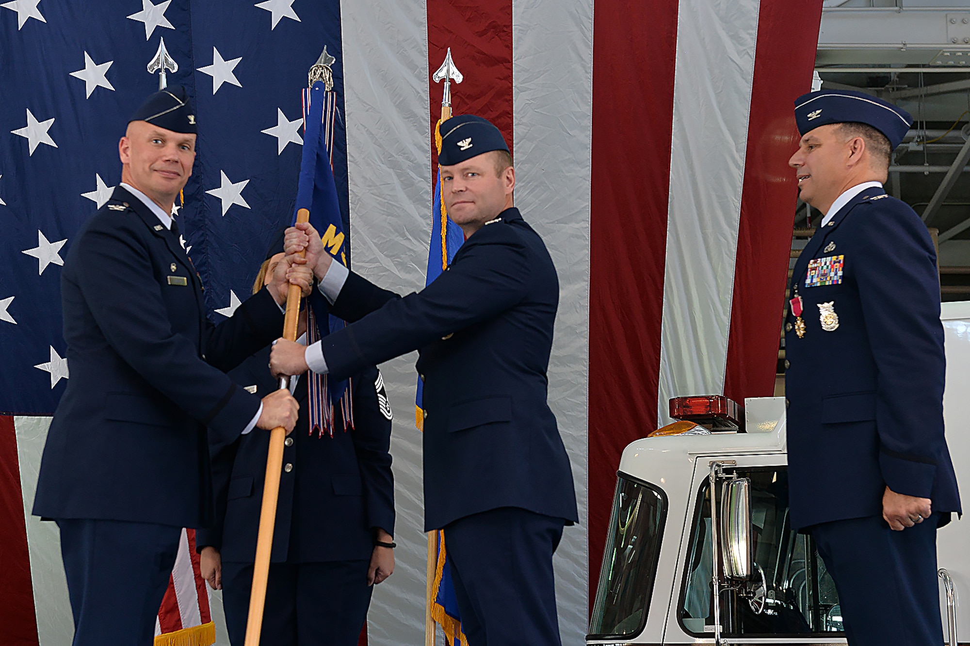 55th Wing Commander Col. Michael Manion, left, presents the 55th Mission Support Group guidon to Col. David Norton, center, as he accepts command of the 55th MSG at Offutt Air Force Base, Nebraska, July 14, 2017. Outgoing 55th MSG Commander Col. Matthew Joganich, right, surrendered command of the 55th MSG, which is responsible for five squadrons encompassing 1,600 individuals who support Air Combat Command’s largest wing and over 50 tenant units.