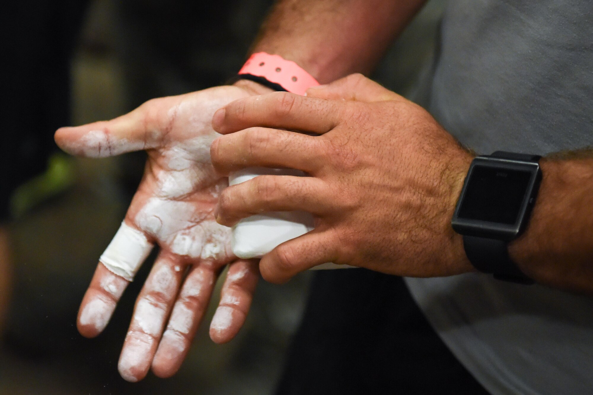A member of Team Barksdale applies chalk to his hands before he attempts the Alpha Warrior course at Barksdale Air Force Base, La., July 11, 2017. The objective is to complete each obstacle on the course and finish with a 100 percent completion rate. (U.S. Air Force photo/Airman 1st Class Stuart Bright)