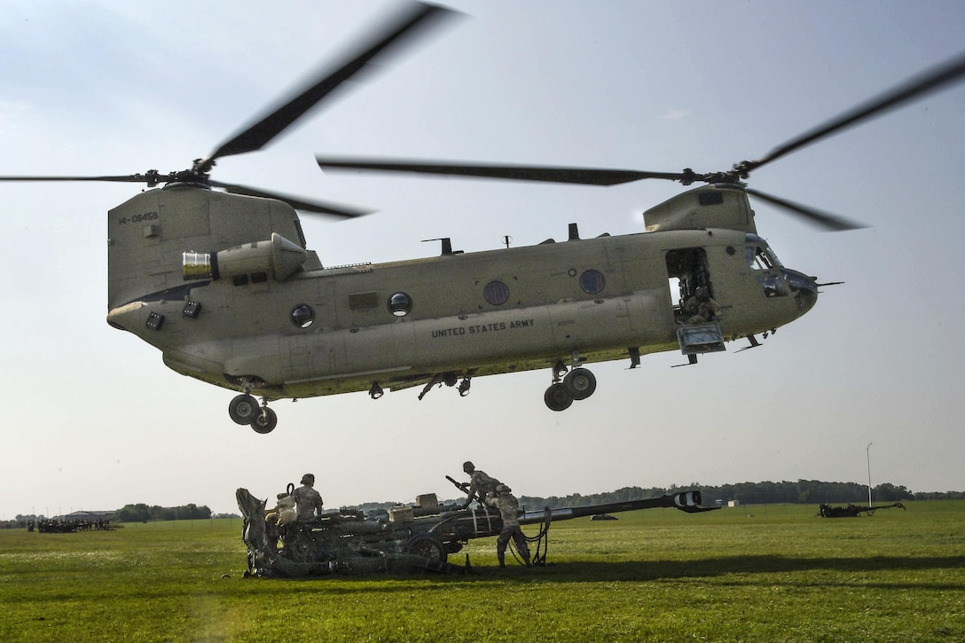 Soldiers use a Boeing CH-47 Chinook helicopter to slingload an M777 howitzer during air assault training at Fort Campbell, Ky., July 19, 2017. The soldiers are assigned to Company B, 6th Battalion, 101st Aviation Regiment, 101st Combat Aviation Brigade, and the 101st Airborne Division Artillery's 1st Battalion, 320th Field Artillery Regiment. Army photo by Sgt. Marcus Floyd