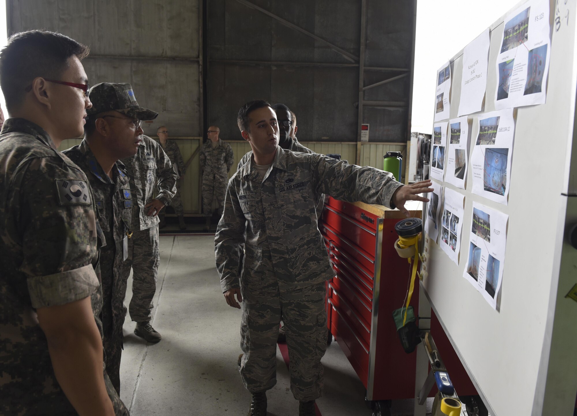 U.S. Air Force Staff Sgt. Joseph Kern, 309th Aircraft Maintenance Group depot aircraft structural maintenance craftsman, briefs Republic of Korea Air Force Col. Cha, Jun Seon, 38th Fighter Group commander, on different corrosion control methods being performed on F-16 Fighting Falcons at Kunsan Air Base, ROK, July 18, 2017. Cha immersed with the 8th Fighter Wing to gain a better understanding of the Wolf Packs role in defending the base and peninsula. (U.S. Air Force photo by Senior Airman Michael Hunsaker/Released)