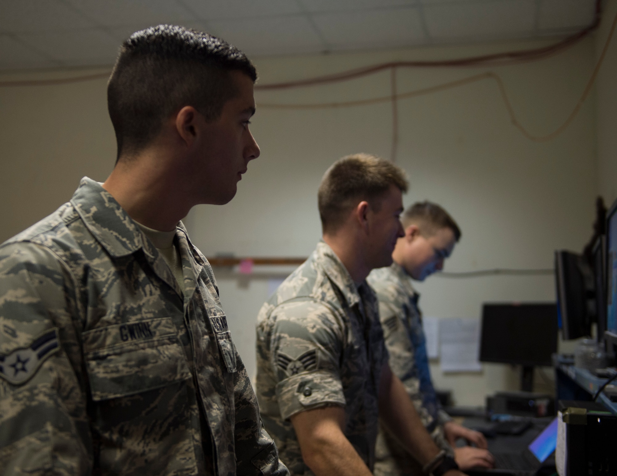 U.S. Air Force Airman 1st Class Robert Gwinn, left, a computer service technician, Senior Airman Andrew Montz, a cyber transport technician, and Airman 1st Class Ethan Morgan, a computer service technician with the 379th Expeditionary Communication Squadron, troubleshoot computer problems at Al Udeid Air Base, Qatar, July 14, 2017. The Airmen are responsible for installing programs, troubleshooting and repairing computer problems, and ensuring that all of the hardware and software systems are functional. (U.S. Air Force photo by Tech. Sgt. Amy M. Lovgren)