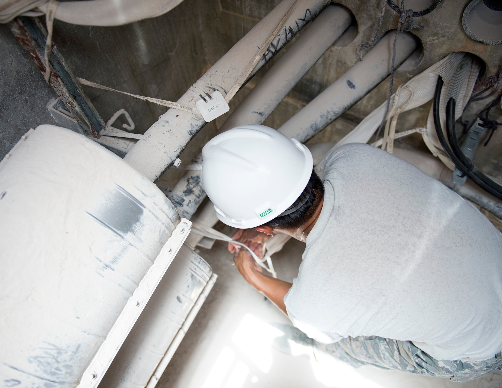 U.S. Air Force Staff Sgt. Aaron Ramelb, a cable and antenna system specialist with the 379th Expeditionary Communication Squadron, secures a fiber optic cable inside a manhole conduit system at Al Udeid Air Base, Qatar, July 14, 2017. Ramelb is part of team of airmen that is responsible for installing, sustaining, and repairing miles of copper and fiber optics cables at Al Udeid Air Base. (U.S. Air Force photo by Tech. Sgt. Amy M. Lovgren)