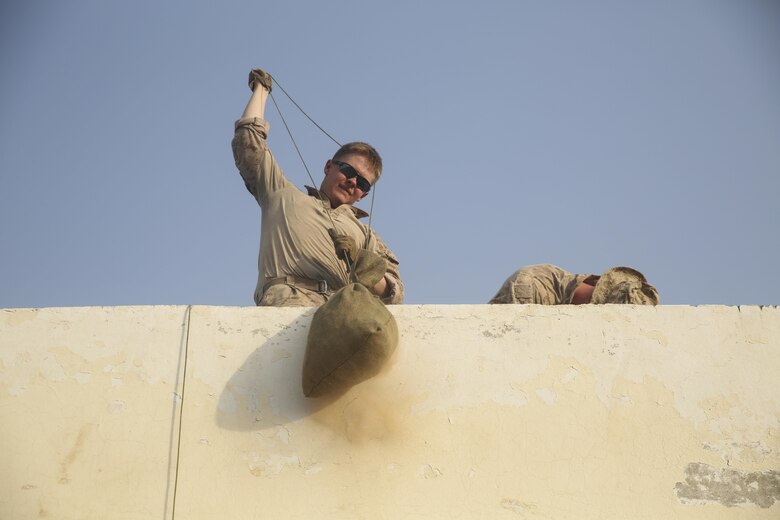 A U.S. Marine with Task Force Southwest raises a sandbag onto a roof to improve defensive posture during Operation Maiwand Four at Camp Shorserack, Afghanistan, July 14, 2017. Advisors from the Task Force assisted their Afghan National Defense and Security Force partners during the operation, which saw elements of the Afghan National Army 215th Corps, 505th Zone National Police and several other forces establish security in the Nawa district center. Together, the U.S. and Afghan forces will work to continue enhancing stability and establishing governance in the region. (U.S. Marine Corps photo by Sgt. Lucas Hopkins)