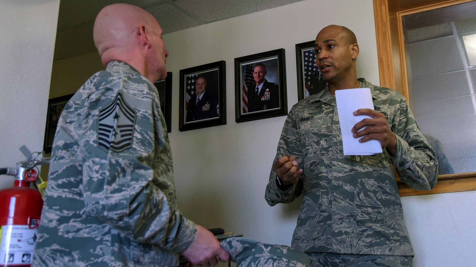 Chief Master Sgt. Thomas F. Good, Twentieth Air Force Command Chief, speaks with Master Sgt. Jerbaine Dancy, 377th Security Forces Squadron plans and programs superintendent, at the base defense operations center at Kirtland Air Force Base, July 18. Dancy explained how the base power grid supplies the power for all of security forces functions. (U.S. Air Force Photo/Senior Airman Chandler Baker)