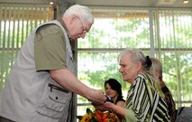 Thomas Perry, retired from the 786th Force Support Squadron after 48 years of service, hands his wife the flag of the United States of America at the Lindberg Hof Dining Facility, Kapaun Air Station, June 30, 2017. As he and his wife prepare for life after retirement, Perry looks forward to the future that involves travel plans, writing, and relaxing. (U.S. Air Force photo by Airman 1st Class Savannah L. Waters)