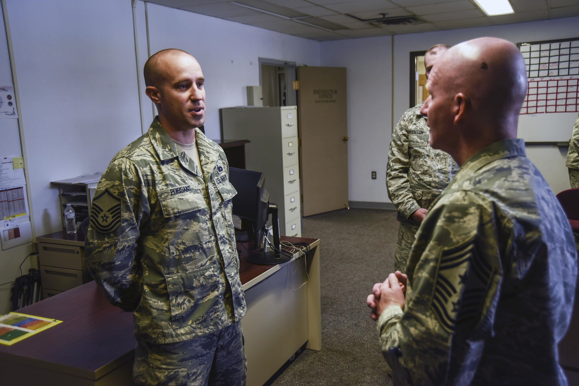 Chief Master Sgt. Thomas F. Good, Twentieth Air Force Command Chief, speaks with Master Sgt. Kelly Poissant, 377th Security Support Squadron superintendent of training, at Kirtland Air Force Base, July 18. Poissant explained the training schedule for defenders on Kirtland. (U.S. Air Force Photo/Senior Airman Chandler Baker)