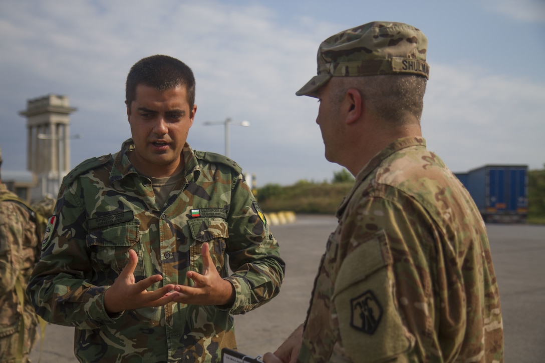 Chaplain (Maj.) Andrew Shulman (right), chaplain with 7th Mission Support Command, speaks with a Bulgarian Civil Military Cooperation partner at the border of Bulgaria and Romania prior to the 2nd Cavalry Regiment bridge crossing in Ruse, Bulgaria, July 17 (U.S. Army Reserve photo by Capt. Jeku Arce, 221st Public Affairs Detachment).