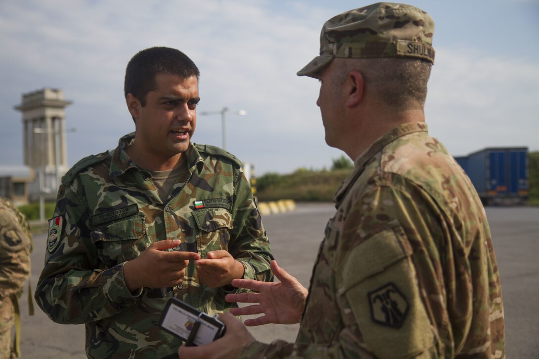 Chaplain (Maj.) Andrew Shulman (right), chaplain with 7th Mission Support Command, speaks with a Bulgarian Civil Military Cooperation partner at the border of Bulgaria and Romania prior to the 2nd Cavalry Regiment bridge crossing in Ruse, Bulgaria, July 17 (U.S. Army Reserve photo by Capt. Jeku Arce, 221st Public Affairs Detachment).