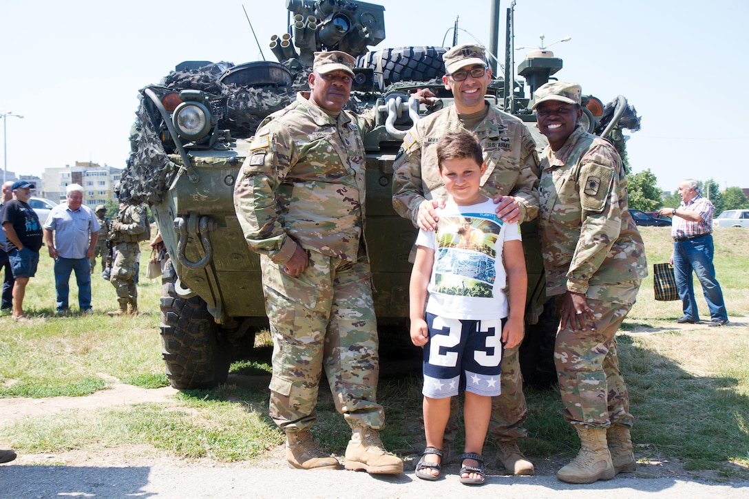 Soldiers of 361st Civil Affairs Brigade pose for a photo with locals of Ruse, Bulgaria at a static display of 2nd Cavalry Regiment strykers and Bulgarian military vehicles, July 17 (U.S. Army Reserve photo by Capt. Jeku Arce, 221st Public Affairs Detachment).