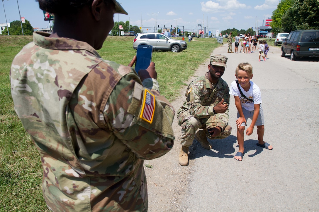 Sgt. Donald Patterson, civil affairs soldier with 361st Civil Affairs Brigade, poses for a photo with a local of Ruse, Bulgaria at a static display of 2nd Cavalry Regiment strykers and Bulgarian military vehicles, July 17 (U.S. Army Reserve photo by Capt. Jeku Arce, 221st Public Affairs Detachment).