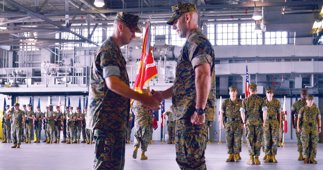 Former commander Lt. Col. William Pacatte III shakes hands with incoming commander Lt. Col. Daniel Murphy after the colors had transferred from hand to hand symbolizing the beginning of a new era at Marine Corps Air Facility.