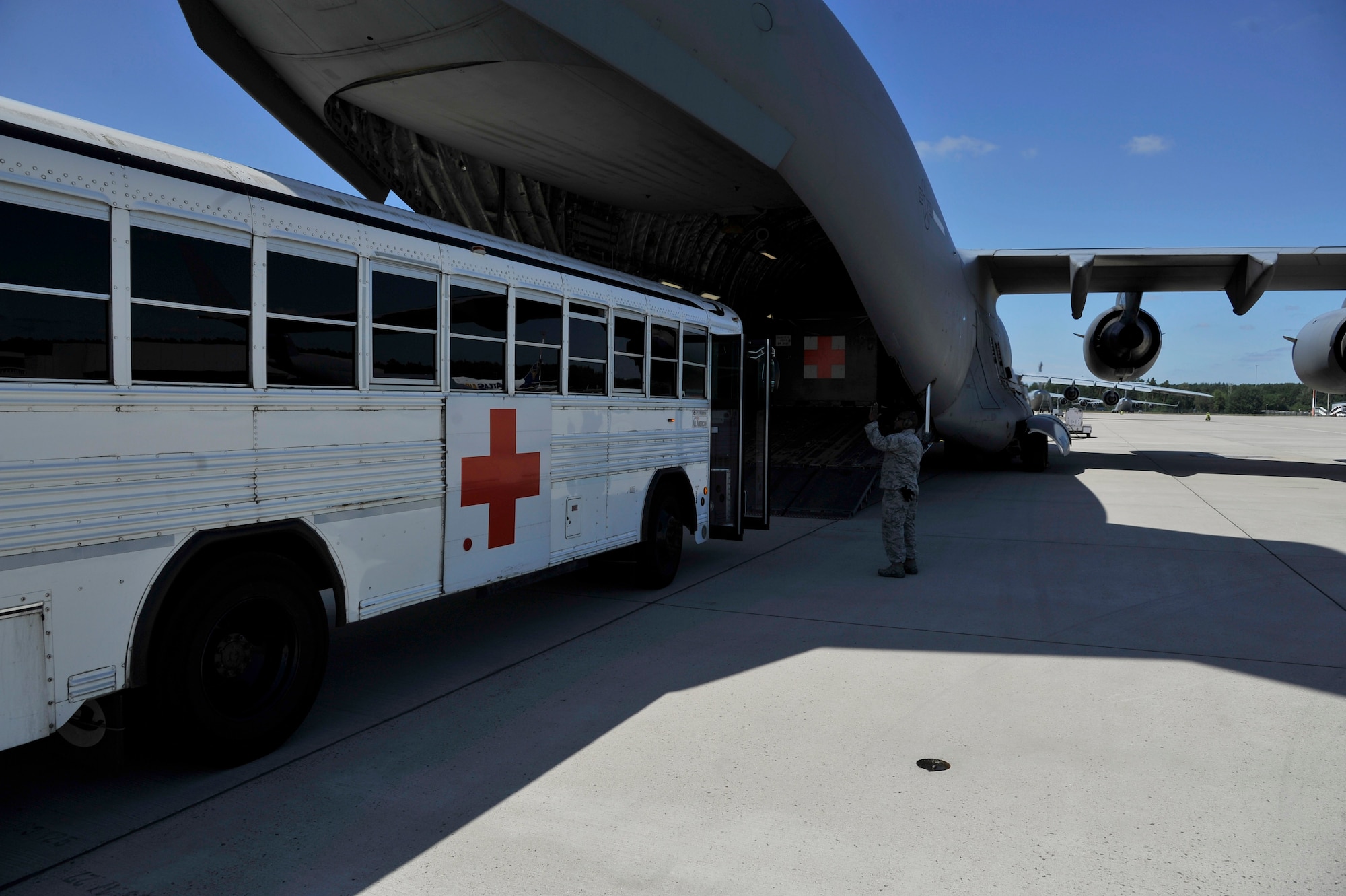 U.S. Air Force Maj. Eric Doggett, En-Route Patient Staging Facility flight commander, speaks to an ambulance bus driver during a patient movement on Ramstein Air Base, Germany, July 13, 2017.  The ERPS primary mission is to care for injured service members in transit from deployed locations to the continental United States where they can receive higher levels of care. (U.S. Air Force photo by Airman 1st Class D. Blake Browning)