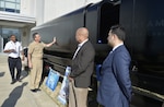 Chief of Naval Research Rear Adm. David Hahn listens as Garry Shields (left), head of Naval Surface Warfare Center, Carderock Division's Disruptive Technology Laboratory, describes the Optionally Manned Technology Demonstrator (OMTD) Big Area Additive Manufacturing (BAAM) test article, which is a 30-foot-long, proof-of-concept hull print modeled after a SEAL delivery vehicle. Hahn was at Carderock's headquarters in West Bethesda, Md., on Feb. 28, 2017, for the annual Naval Innovative Science and Engineering (NISE) Technical Exchange Meeting (TEM). (U.S. Navy photo by Devin Pisner/Released)