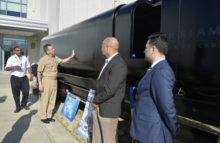 Chief of Naval Research Rear Adm. David Hahn listens as Garry Shields (left), head of Naval Surface Warfare Center, Carderock Division's Disruptive Technology Laboratory, describes the Optionally Manned Technology Demonstrator (OMTD) Big Area Additive Manufacturing (BAAM) test article, which is a 30-foot-long, proof-of-concept hull print modeled after a SEAL delivery vehicle. Hahn was at Carderock's headquarters in West Bethesda, Md., on Feb. 28, 2017, for the annual Naval Innovative Science and Engineering (NISE) Technical Exchange Meeting (TEM). (U.S. Navy photo by Devin Pisner/Released)