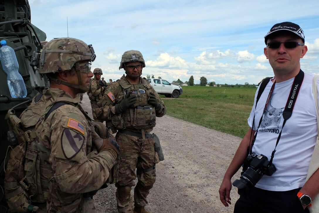 Battle Group Poland soldiers talk with a resident in Suwalki, Poland, who came out to the field to meet them during the Bull Run training exercise, July 16, 2017. Army photo by Spc. Kevin Wang