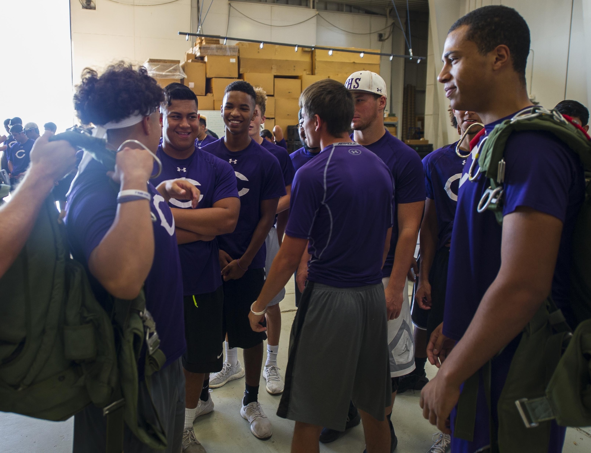 Clovis High School football players try on parachutes at the 26th Special Tactics Squadron during their tour at Cannon Air Force Base, NM, July 19, 2017. Students experienced what it felt like to wear gear that 26th STS Airmen are expected to complete the mission with. (U.S. Air Force photo by Senior Airman Lane T. Plummer)