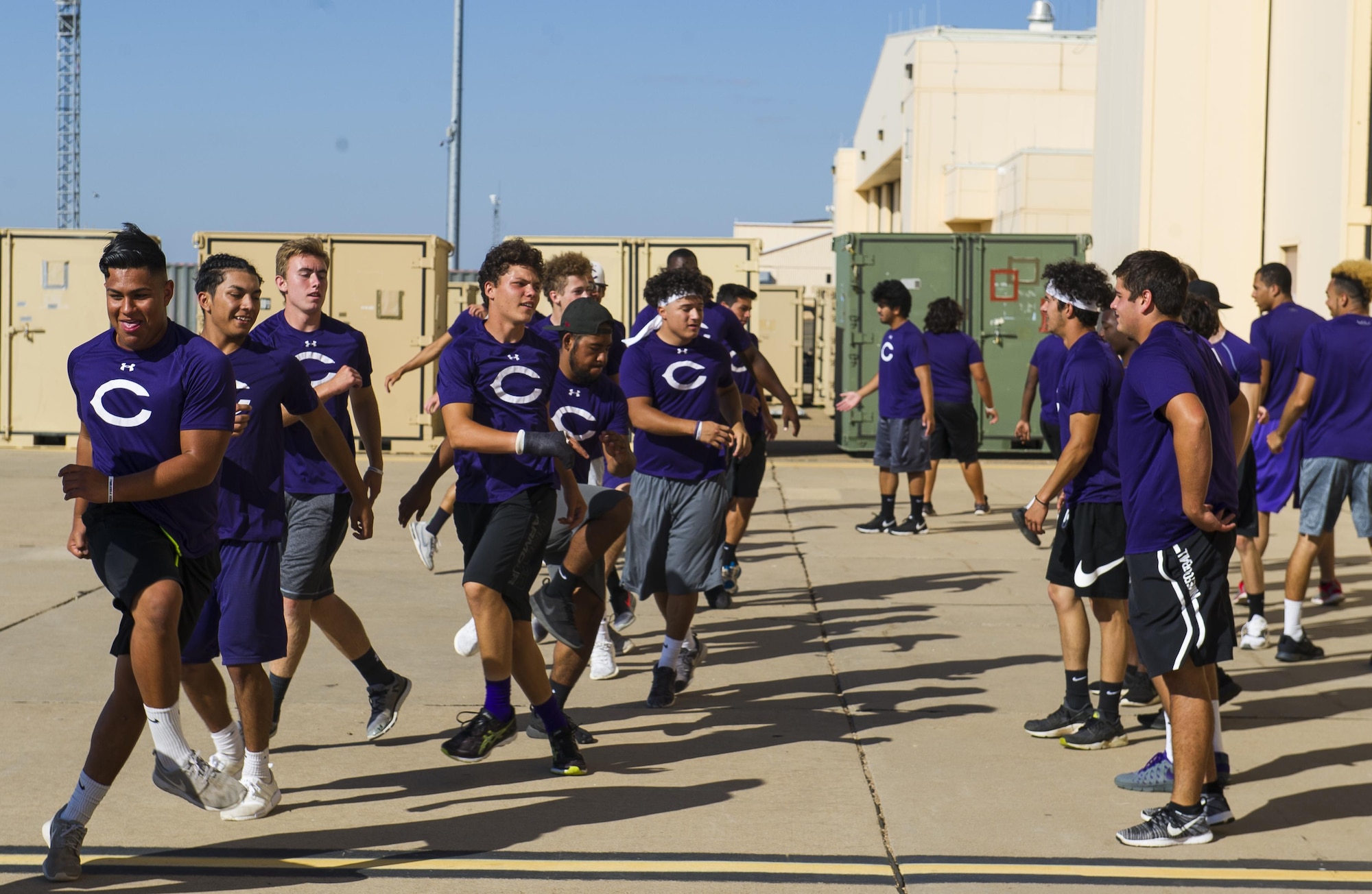 Clovis High School football players exercise on the flightline during their tour at Cannon Air Force Base, NM, July 19, 2017. From practicing physical form on the flightline to sweating through sets in the gym, the students followed a regimen that special tactics Airmen use to maintain a high standard of physical ability. (U.S. Air Force photo by Senior Airman Lane T. Plummer)