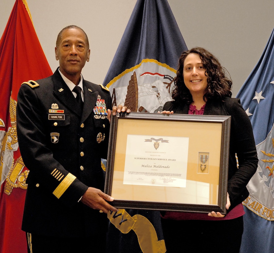 Former DLA Troop Support Commander Army Brig. Gen. Charles Hamilton presents contracting officer Maliza Maldonado a DLA Superior Civilian Service Award and recognizes her as the DLA Troop Support 2016 Employee of the Year during a ceremony June 6 in Philadelphia. The awards cited Maldonado's handling of an 18-month, $43M bridge contract for the industrial hardware needed to support three air logistics complexes at Ogden, Utah; Oklahoma City; and Warner Robins, Georgia.