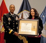 Former DLA Troop Support Commander Army Brig. Gen. Charles Hamilton presents contracting officer Maliza Maldonado a DLA Superior Civilian Service Award and recognizes her as the DLA Troop Support 2016 Employee of the Year during a ceremony June 6 in Philadelphia. The awards cited Maldonado's handling of an 18-month, $43M bridge contract for the industrial hardware needed to support three air logistics complexes at Ogden, Utah; Oklahoma City; and Warner Robins, Georgia.