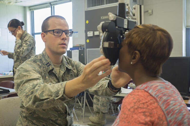 Air Force Capt. Matthew Stoltz, a physician assistant with 171st Air Refueling Squadron, examines the eyes of Kim Harrell-Jones, a patient attending Innovative Readiness Training Louisiana Care 2017, at Amite High School in Amite, La., July 15, 2017. IRT Louisiana Care 2017 offers optometry, dental and medical care to the local community at no cost to patients. (U.S. Marine Corps Photo by Lance Cpl. Niles Lee/Released)