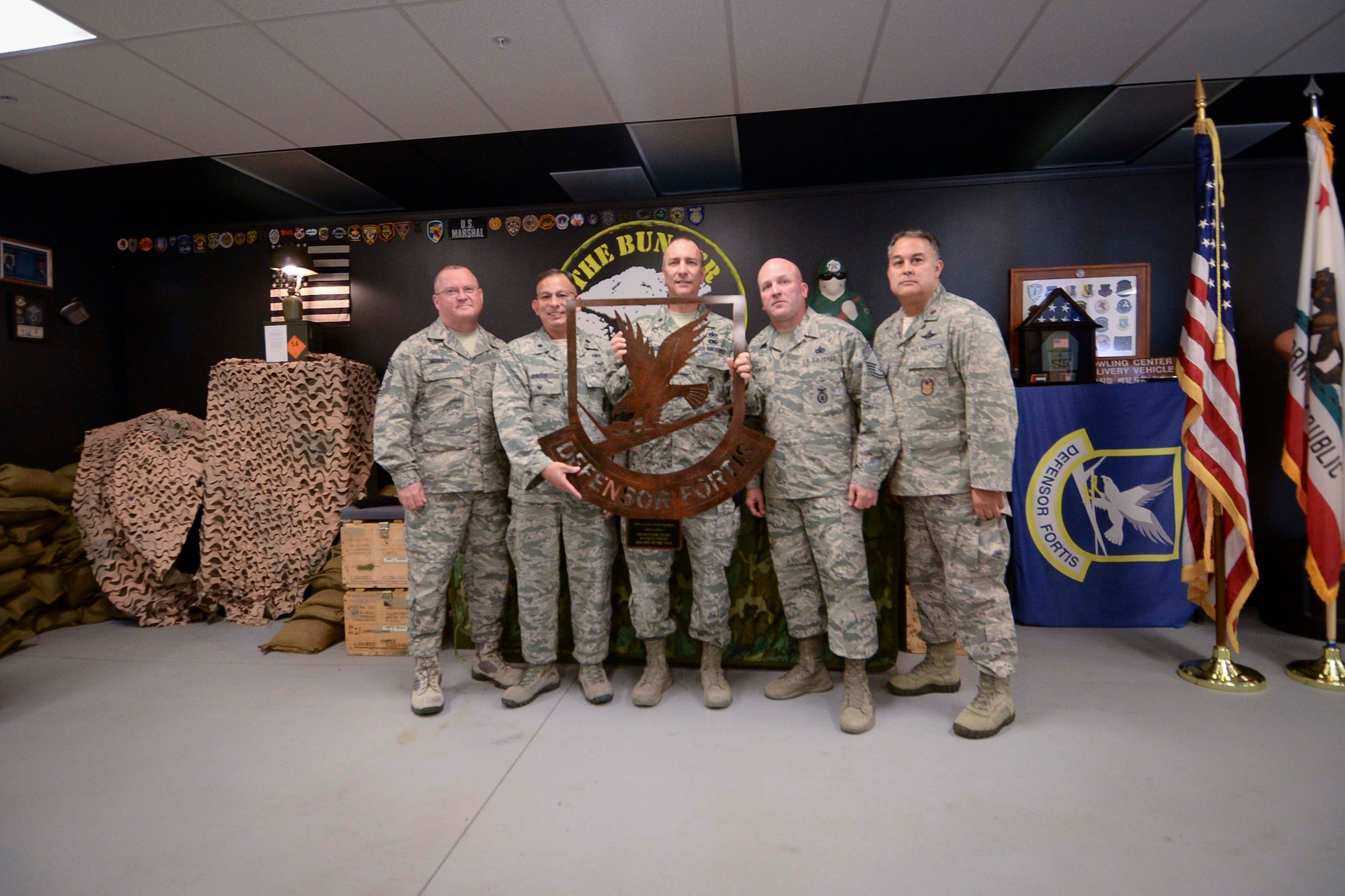 Chief Master Sgt. Todd Miskelly, Air National Guard Security Forces Functional Manager and Lt. Col. Brian Griefer, Operations and Training Branch Chief, NCB/A4S present the Air National Guard Security Forces 2016 Unit of the Year award to the 129th Security Forces Squadron during a ceremony at Moffett Air National Guard Base, Calif., July 18, 2017. (U.S. Air National Guard photo by Senior Airman Zachiah Roberson/released)