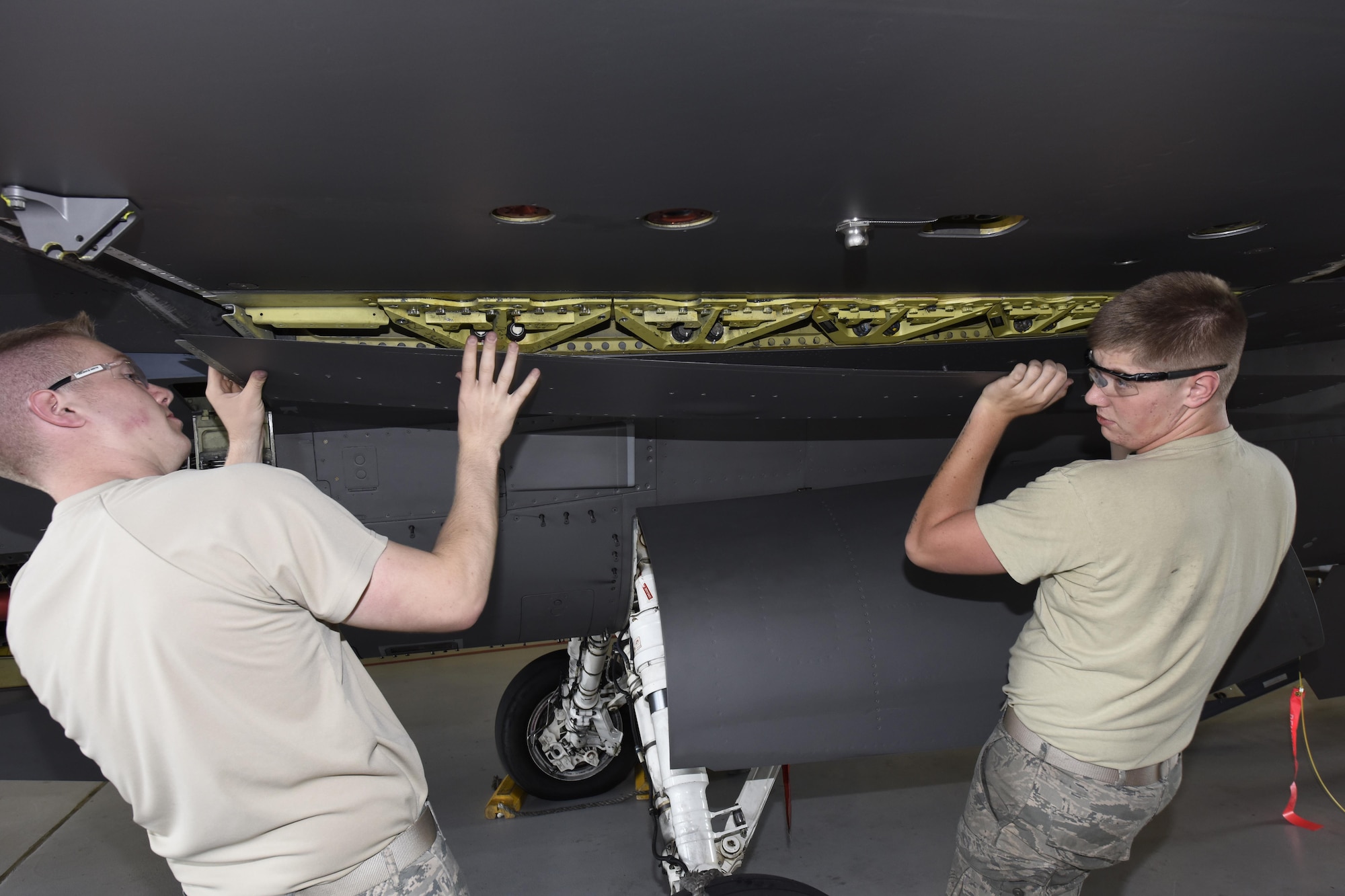 Airman 1st Class Joseph Schuch, and Senior Airman Austin Cole, 114th Aircraft Maintenance Squadron phase mechanics, removed a panel from under the wing of an F-16 during the De-paneling Phase of a phase maintenance inspection at Joe Foss Field, July 8, 2017.  Each aircraft is required to go through a phase inspection every 400 flight hours to ensure all systems are functioning with in Air Force regulations.  (U.S. Air National Guard photo by Master Sgt. Christopher Stewart/Released)
