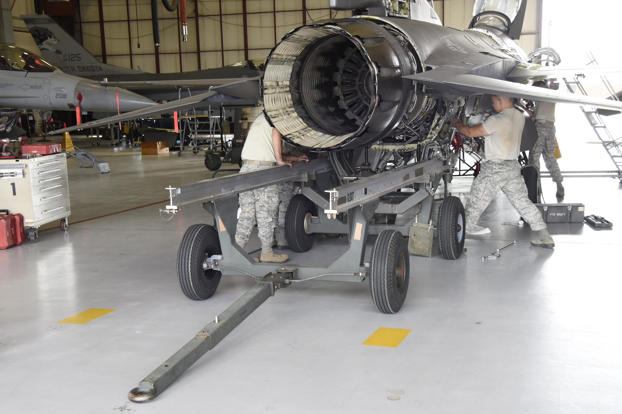 114th Aircraft Maintenance Squadron engine shop Airmen remove the engine of an F-16 during the De-paneling Phase of a phase maintenance inspection at Joe Foss Field, July 8, 2017.  Each aircraft is required to go through a phase inspection every 400 flight hours to ensure all systems are functioning within Air Force regulations.  (U.S. Air National Guard photo by Master Sgt. Christopher Stewart/Released)