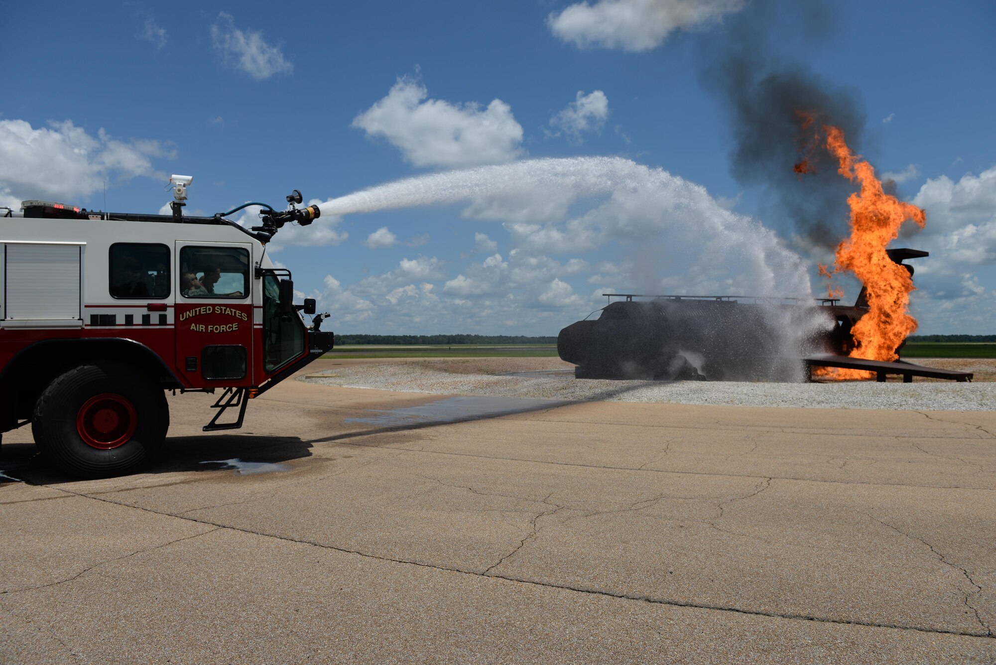 Col. William Denham, 14th Flying Training Wing Vice Commander, watches from the passenger seat of a T-19 Stryker as a fireman puts out a simulated aircraft fire July 17, 2017, on Columbus Air Force Base, Mississippi. Fire Protection uses the metal aircraft to simulate a crash and practices their emergency procedures. (U.S. Air Force photo by Airman 1st Class Keith Holcomb)
