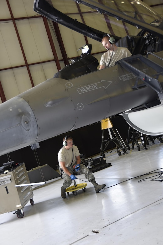 Staff Sgt. Lance Gushwa, 114th Aircraft Maintenance Squadron phase mechanic, manipulated controls inside an f-16 while Tech Sgt. Beau Bartscher, 114th Aircraft Maintenance Squadron phase mechanic checked for leaks in the hydraulics systems at Joe Foss Field, July 8, 2017.  Each aircraft is required to go through a phase inspection every 400 flight hours to ensure all systems are functioning with in Air Force regulations.  (U.S. Air National Guard photo by Master Sgt. Christopher Stewart/Released)
