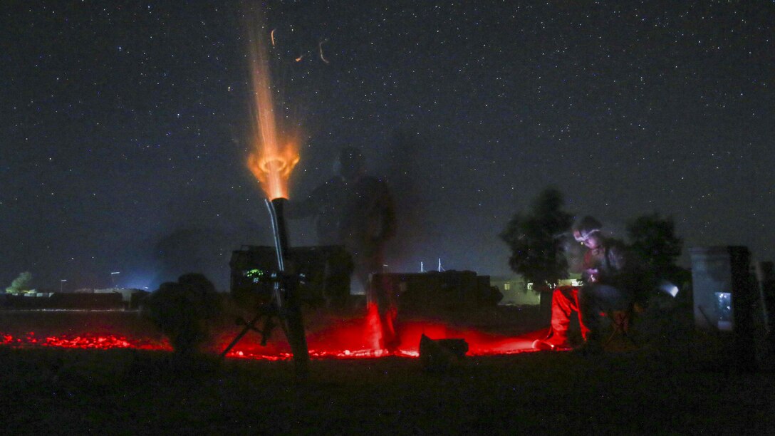 Marines fire a nonexplosive illumination round at night from an 81 mm mortar to deter enemy activity.