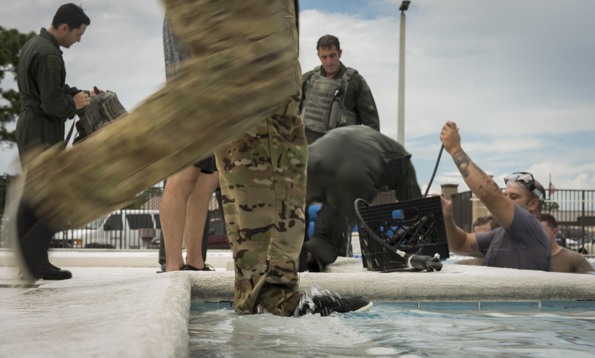 An 8th Special Operations Squadron aircrew member enters the base pool for rotary wing water survival training at Hurlburt Field, Fla., July 18, 2017. The 1st SOSS SERE specialists with the 1st Special Operations Support Squadron conduct rotary wing water survival training quarterly to ensure aircrew are proficient on emergency procedure skill sets. (U.S. Air Force photo by Airman 1st Class Joseph Pick)