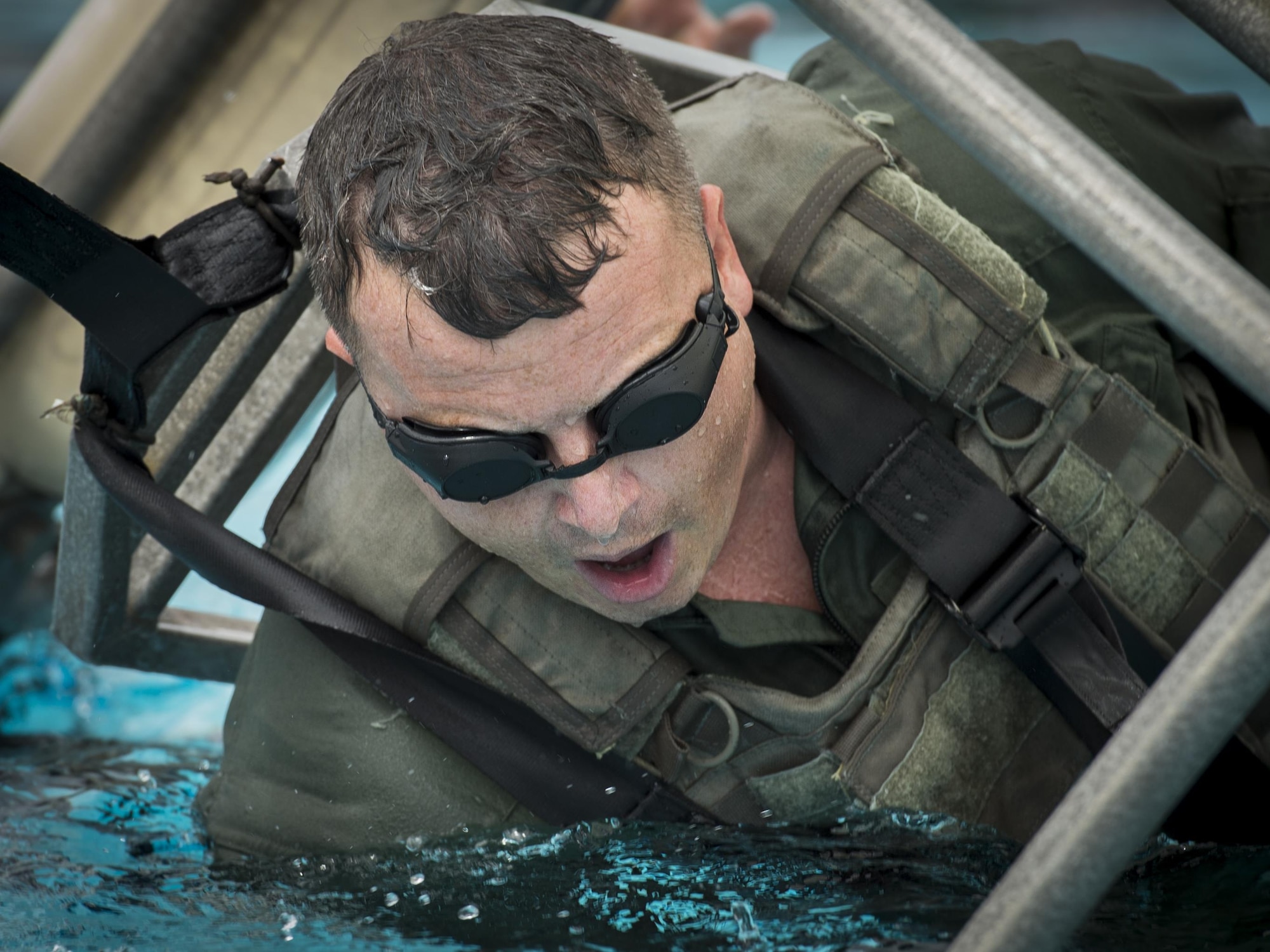 Maj. Richard Fogel, a flight safety officer with Air Force Special Operations Command, prepares to be submerged during rotary wing water survival training at Hurlburt Field, Fla., July 18, 2017. Survival, evasion, resistance and escape specialists with the 1st Special Operations Support Squadron led rotary wing water survival training to ensure aircrew are proficient on emergency procedure skill sets if ever faced with a real-world incident. (U.S. Air Force photo by Airman 1st Class Joseph Pick)