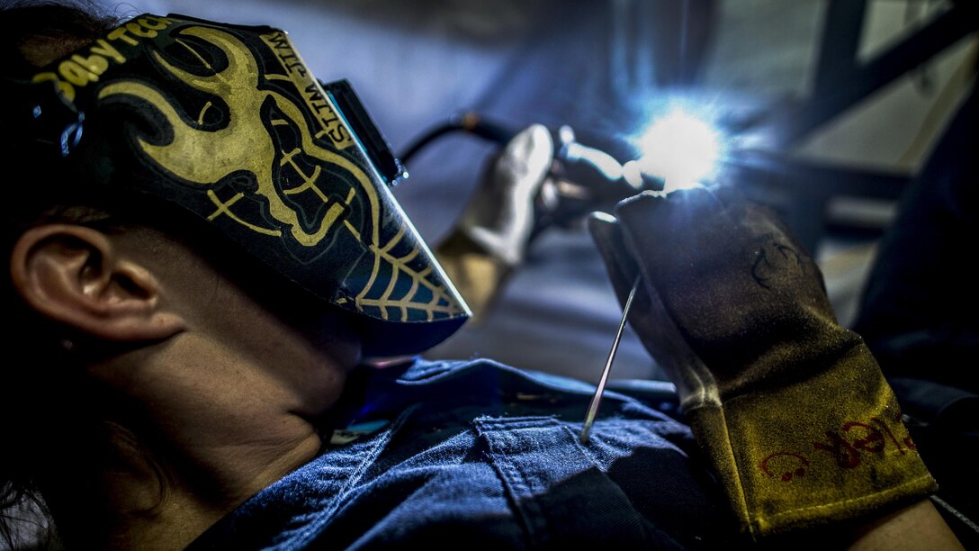 Navy Petty Officer 3rd Class Ashley Peeler welds tables on the mess decks aboard the aircraft carrier USS George H.W. Bush in the Mediterranean Sea, July 17, 2017. The Bush and its carrier strike group are in the U.S. 6th Fleet area of operations supporting national security interests in Europe and Africa. Navy photo by Seaman Zachary Wickline