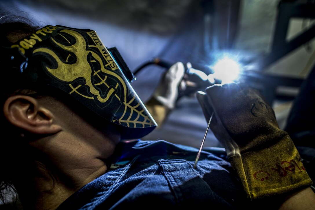 Navy Petty Officer 3rd Class Ashley Peeler welds tables on the mess decks aboard the aircraft carrier USS George H.W. Bush in the Mediterranean Sea, July 17, 2017. The Bush and its carrier strike group are in the U.S. 6th Fleet area of operations supporting national security interests in Europe and Africa. Navy photo by Seaman Zachary Wickline