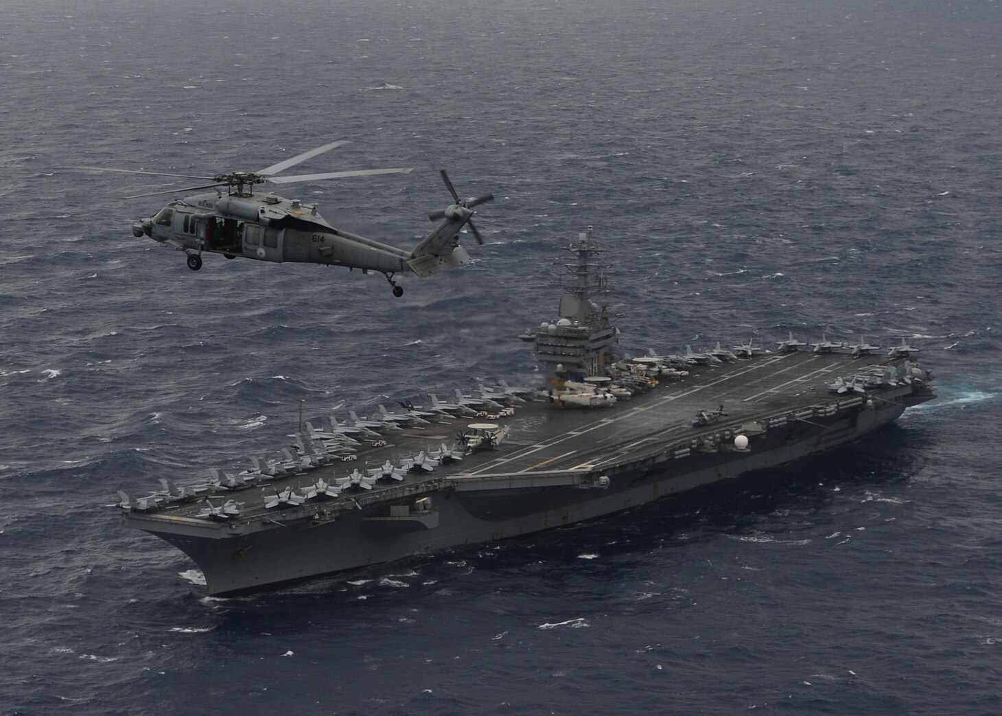 BAY OF BENGAL (July 17, 2017) An MH-60S Sea Hawk Helicopter from the "Eightballers" of Helicopter Sea Combat Squadron (HSC) 8 hovers above the aircraft carrier USS Nimitz (CVN 68) during a photo exercise with the Indian Navy and Japan Maritime Self-Defense Force, July 17, 2017, in the Bay of Bengal as part of Exercise Malabar 2017. Malabar 2017 is the latest in a continuing series of exercises between the Indian Navy, JMSDF and U.S. Navy that has grown in scope and complexity over the years to address the variety of shared threats to maritime security in the Indo-Asia-Pacific region. (U.S. Navy photo by Mass Communication Specialist 3rd Class Cole Schroeder)