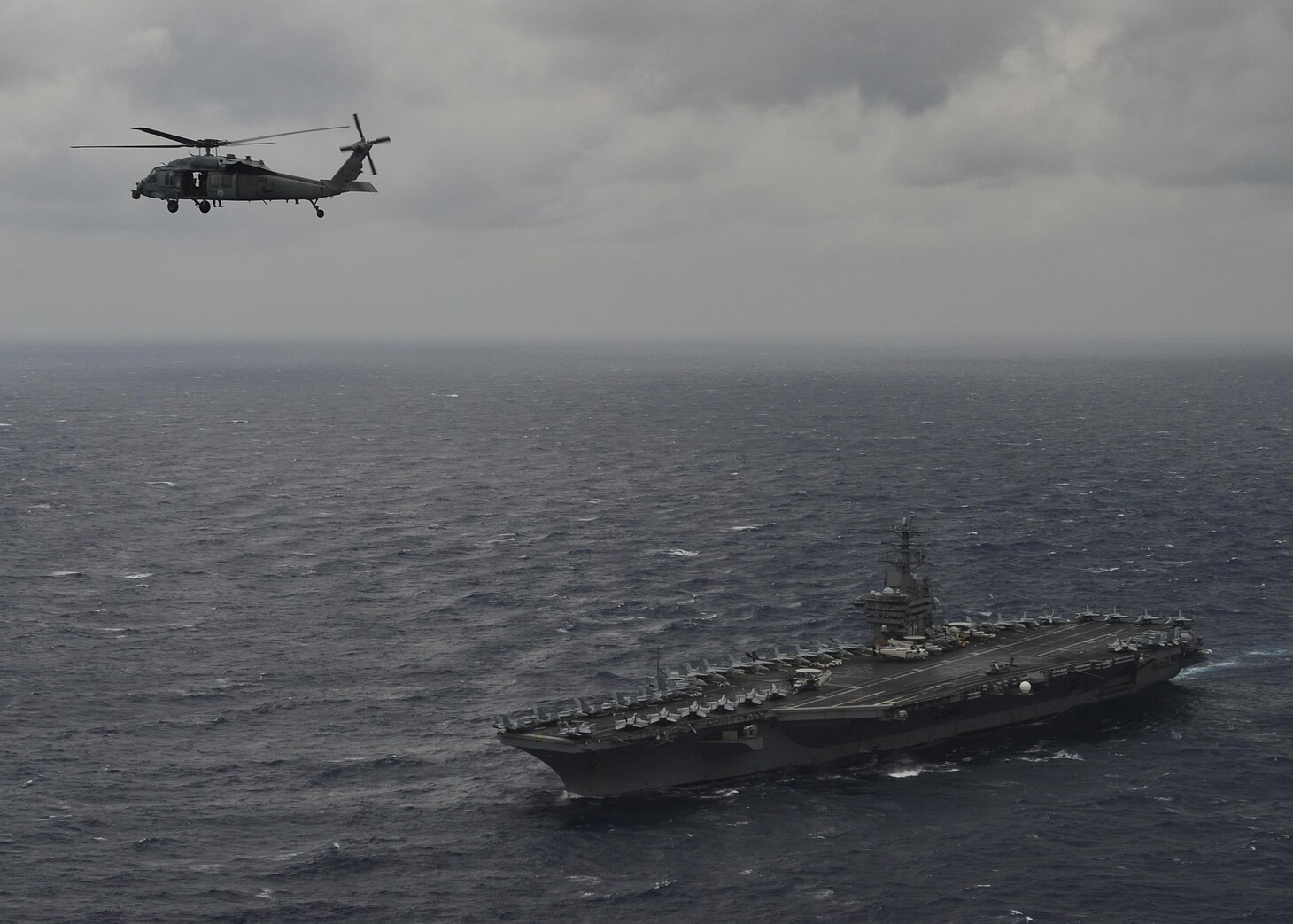 BAY OF BENGAL (July 17, 2017) An MH-60S Sea Hawk Helicopter from the "Eightballers" of Helicopter Sea Combat Squadron (HSC) 8 hovers above the aircraft carrier USS Nimitz (CVN 68) during a photo exercise with the Indian Navy and Japan Maritime Self-Defense Force, July 17, 2017, in the Bay of Bengal as part of Exercise Malabar 2017. Malabar 2017 is the latest in a continuing series of exercises between the Indian Navy, JMSDF and U.S. Navy that has grown in scope and complexity over the years to address the variety of shared threats to maritime security in the Indo-Asia-Pacific region. (U.S. Navy photo by Mass Communication Specialist 3rd Class Cole Schroeder)