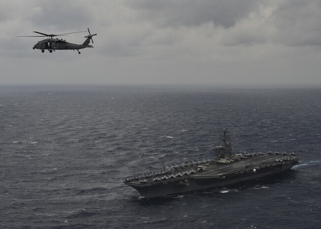 BAY OF BENGAL (July 17, 2017) An MH-60S Sea Hawk Helicopter from the "Eightballers" of Helicopter Sea Combat Squadron (HSC) 8 hovers above the aircraft carrier USS Nimitz (CVN 68) during a photo exercise with the Indian Navy and Japan Maritime Self-Defense Force, July 17, 2017, in the Bay of Bengal as part of Exercise Malabar 2017. Malabar 2017 is the latest in a continuing series of exercises between the Indian Navy, JMSDF and U.S. Navy that has grown in scope and complexity over the years to address the variety of shared threats to maritime security in the Indo-Asia-Pacific region. (U.S. Navy photo by Mass Communication Specialist 3rd Class Cole Schroeder)